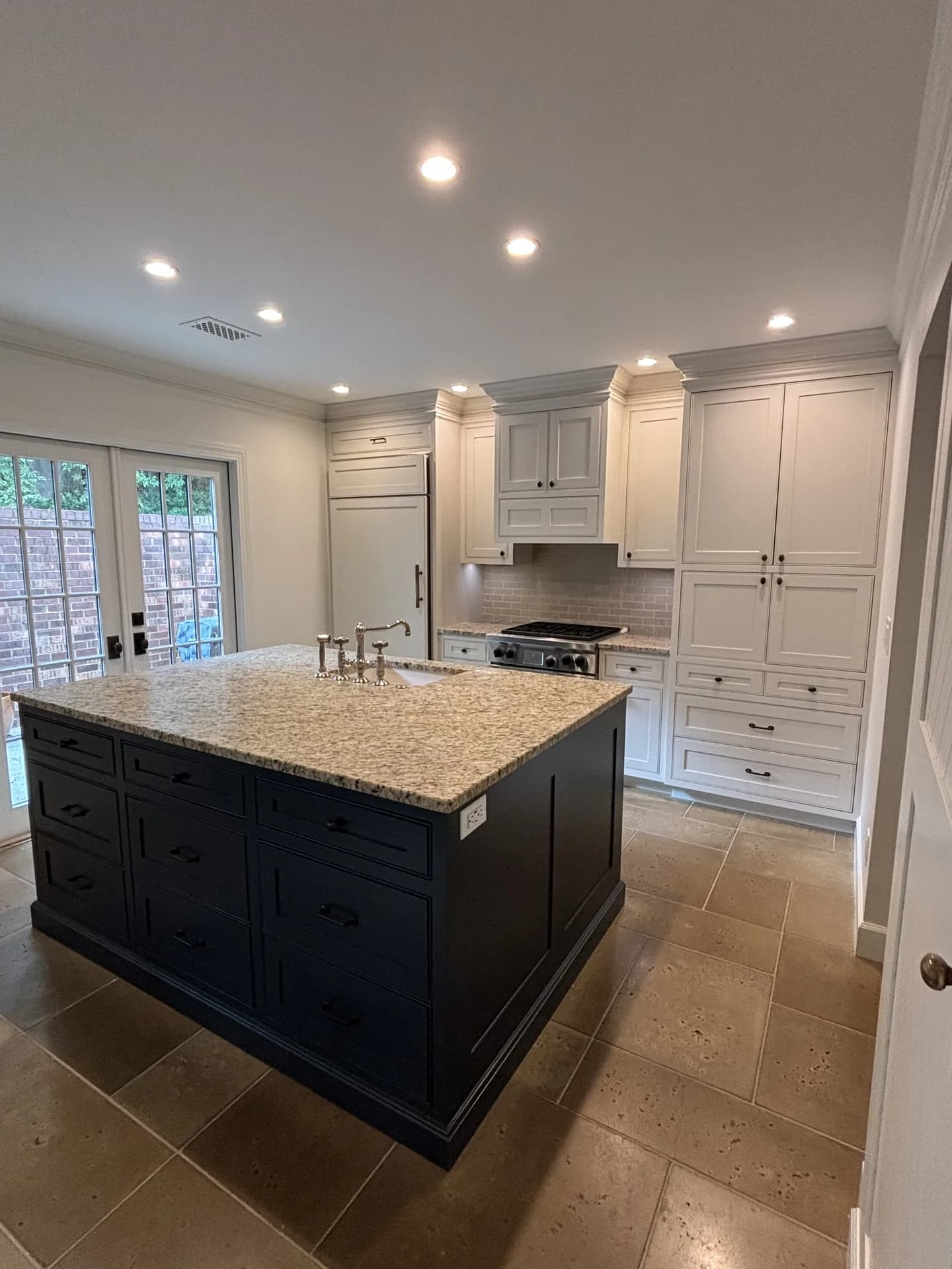 Finished white kitchen cabinets and a navy island