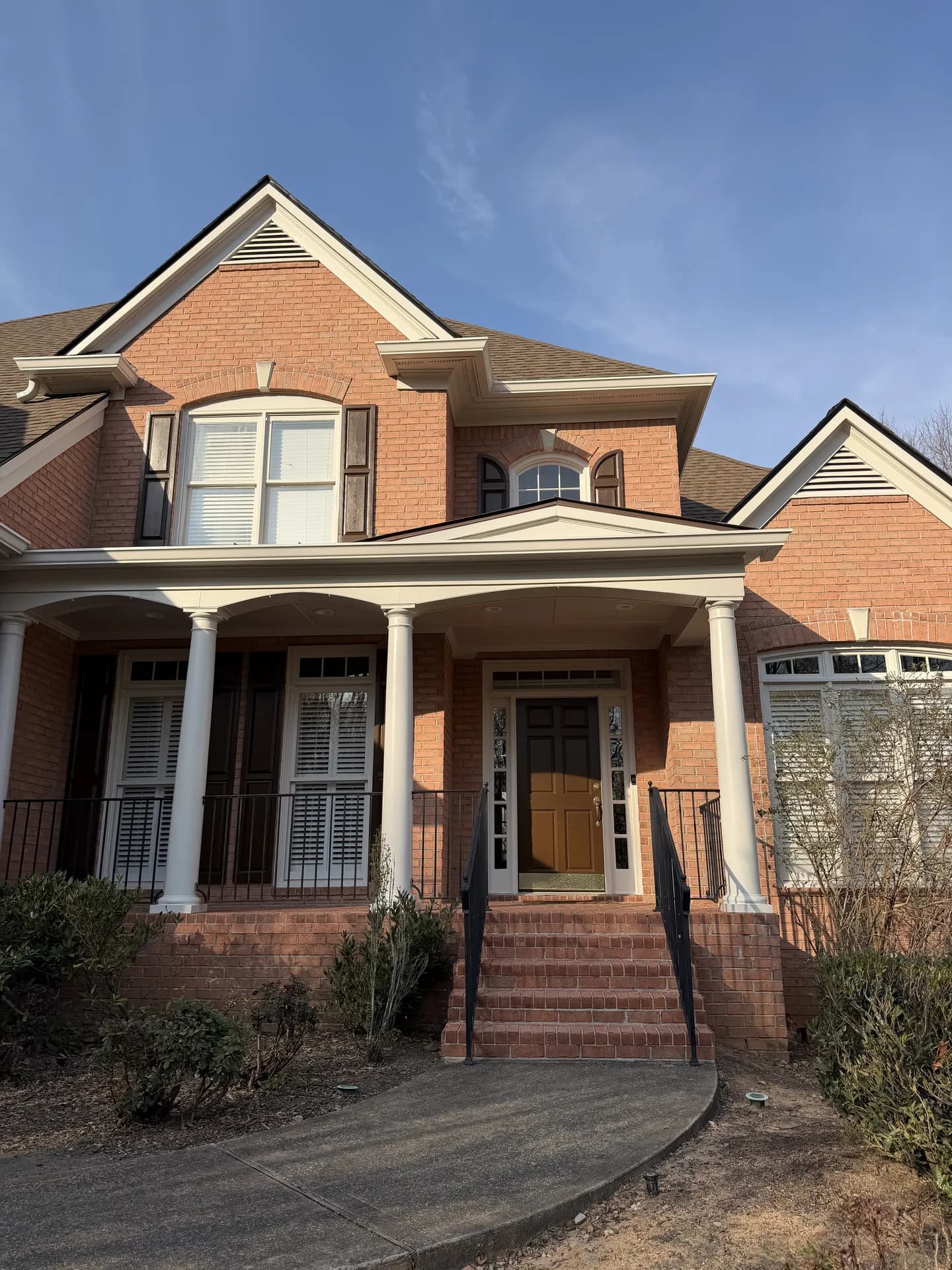Brick home with arched windows and a covered front porch