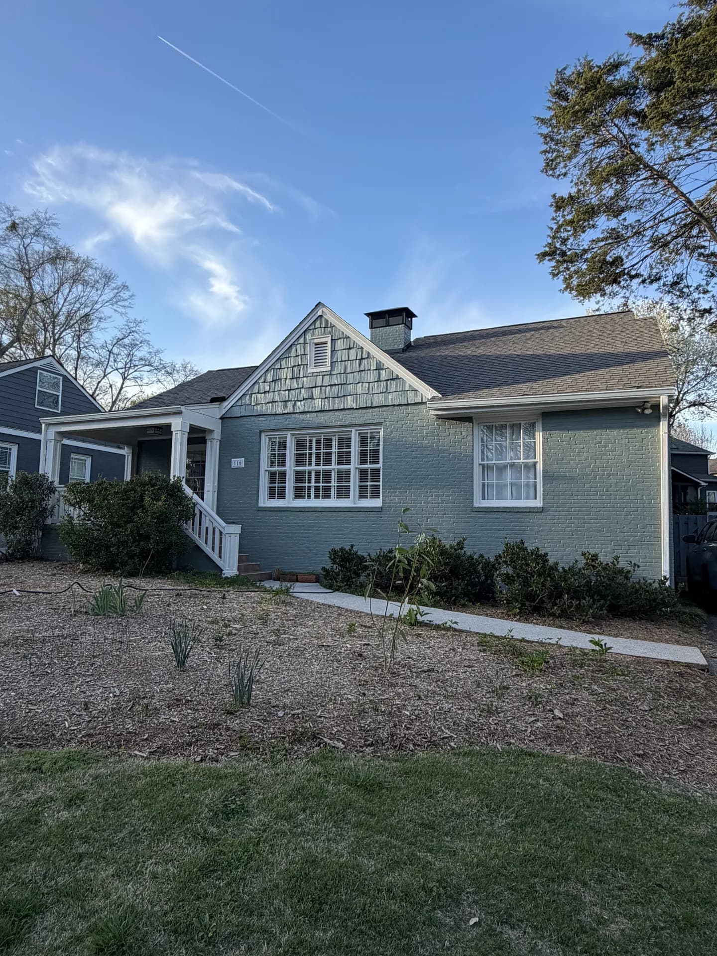 Older bungalow with gables, wood details and painted brick
